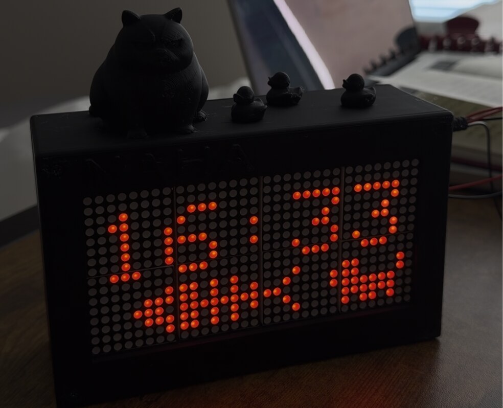 The finished Matrix Clock with a cat and three ducks on top